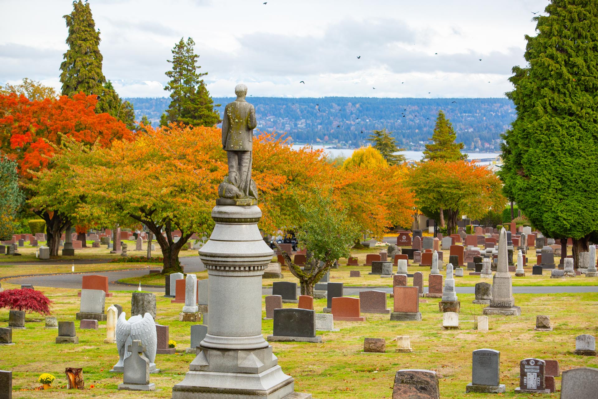 view of the lake from the cemetery over the autumn-colored leaves